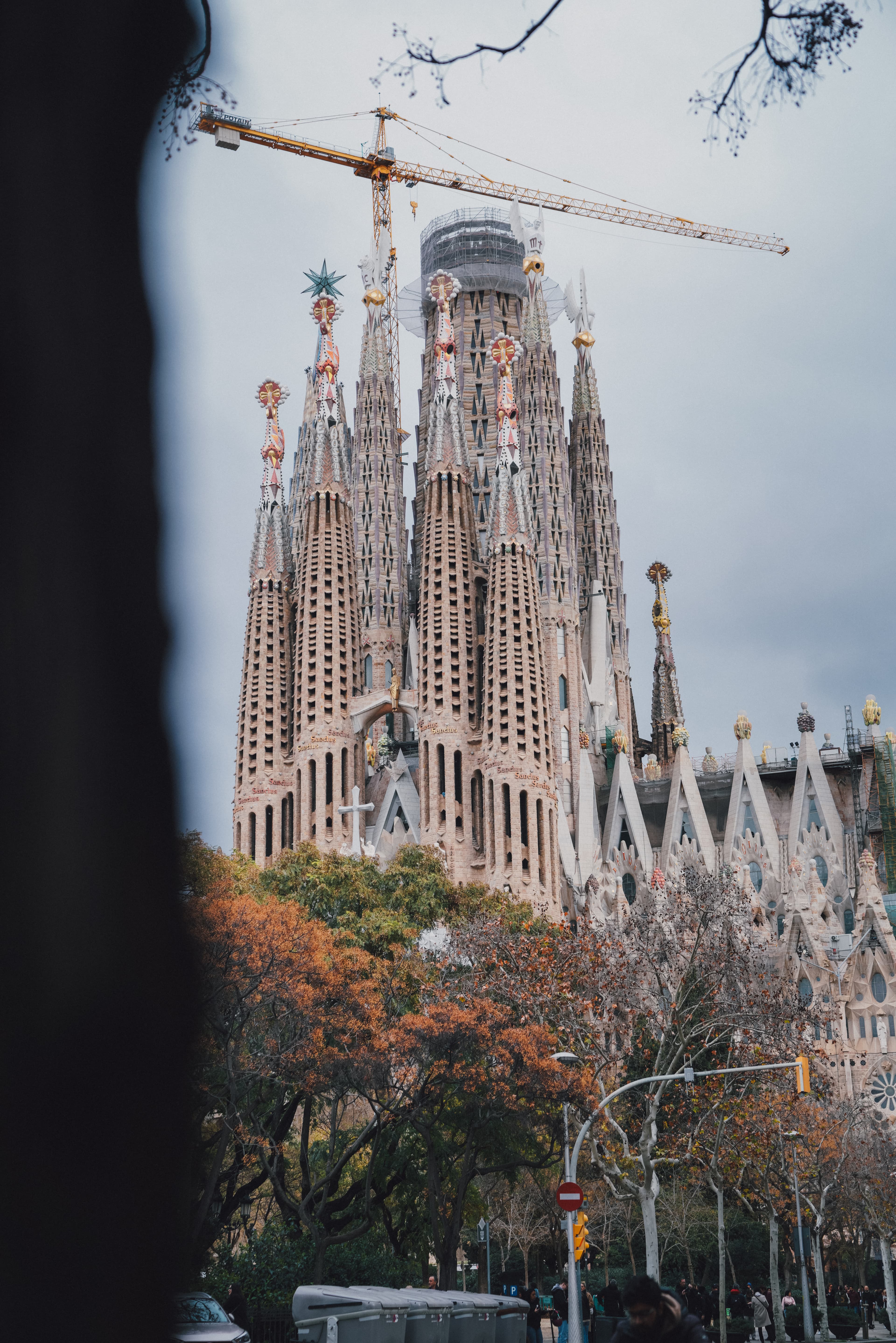 La Sagrada Famรญlia cathedral in Barcelona surrounded by cranes during construction.